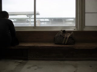 曇った窓と古い鞄(移動の途中)。背景に人物が一人写る