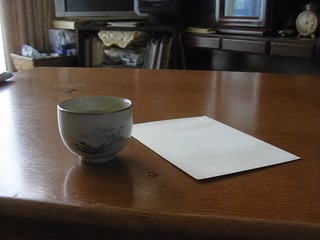 湯のみと伏せた白い紙(机へ向かったついで)