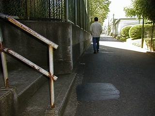 階段脇の古い手すり(移動の途中)。背景に人物が一人写る