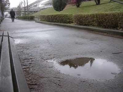小さな水たまり（少し足を止めた時）。背景に人物が一人写る