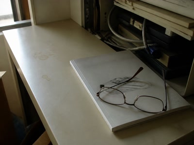 閉じた説明書と眼鏡（机へ座った時）