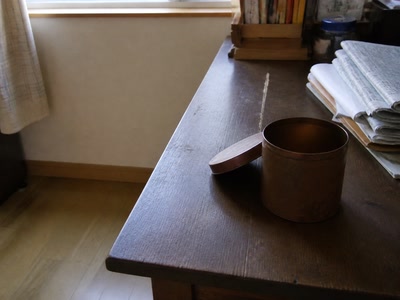 空の茶筒と新聞（小銭をしまう途中）