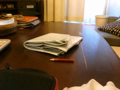 折った新聞と短い赤鉛筆(椅子へ座った時)