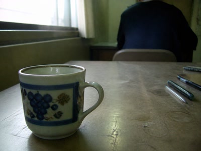 父を思い出す古いカップ（椅子へ座った後）。背景に人物が一人写る