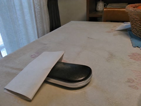 二つ折りの紙と眼鏡入れ(椅子へ座った時)
