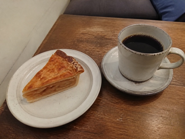 喫茶店のアップルパイと珈琲。画面端にほかの客の服が少し写っている